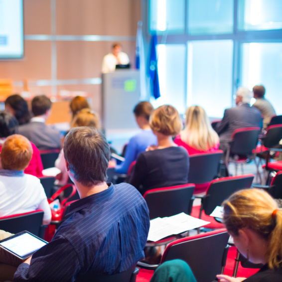 Eine Gruppe Menschen von hinten während eines Vortrags