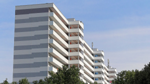 Hochhaus mit weiß-grau gestreifter Fassade und Aufzugstürmen von der Seite