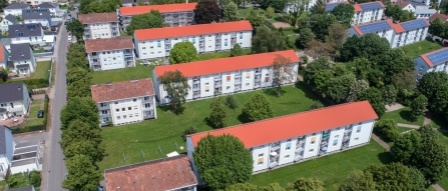 sanierte Wohnhäuser mit 3 Etagen, Satteldächern, helle Fassaden. Rundum Grünflächen mit Bäumen