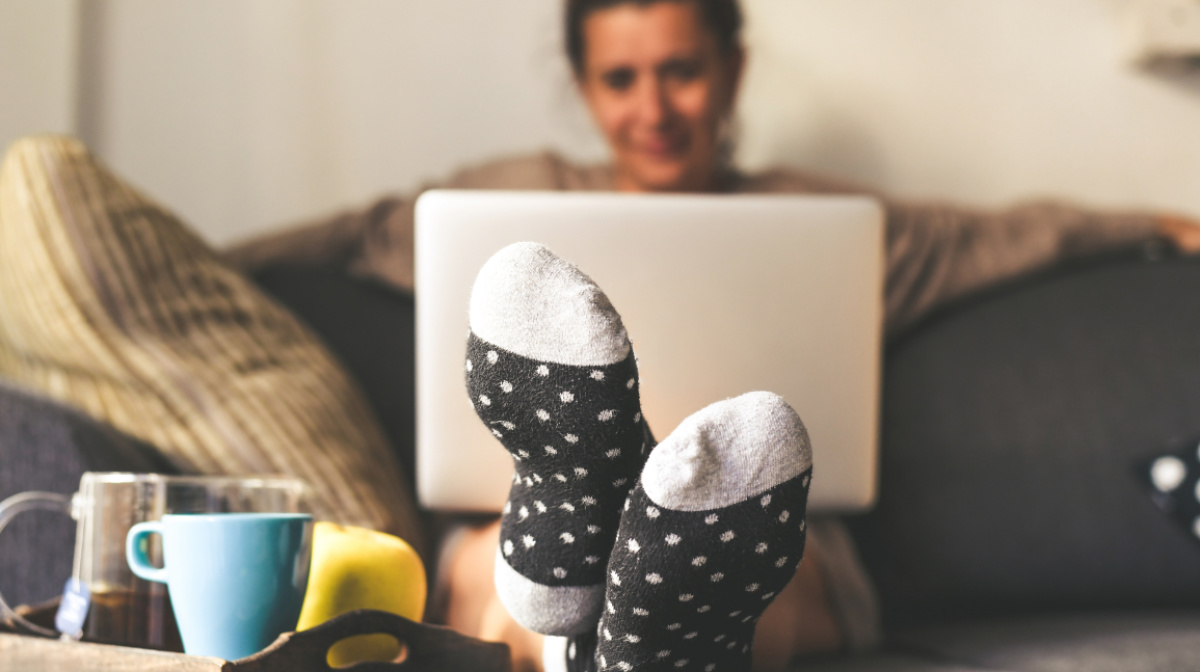 Frau sitzt mit dem Laptop auf der Couch