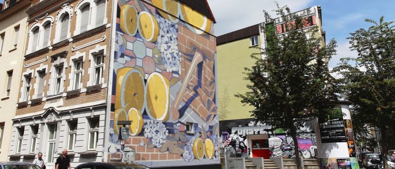 künstlerische Gestaltung mit Motiven aus Zitronen, Mauersteinen an einem Giebel