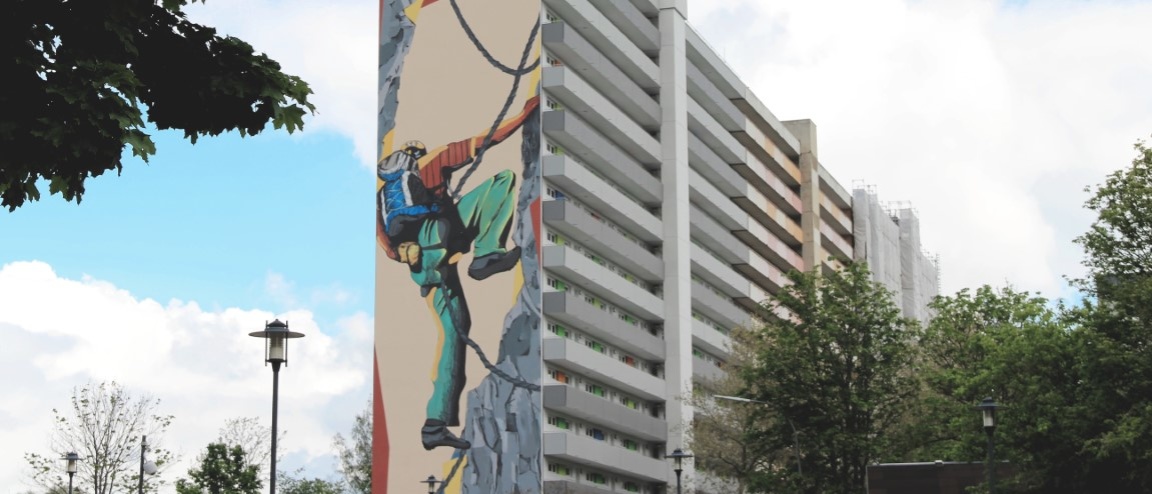 140 Meter langes Hochhaus mit 15 Etagen, saniert, vorne Laubengänge mit hellgrauen Brüstungen. Giebel mit Graffito, das einen Bergsteier zeigt.