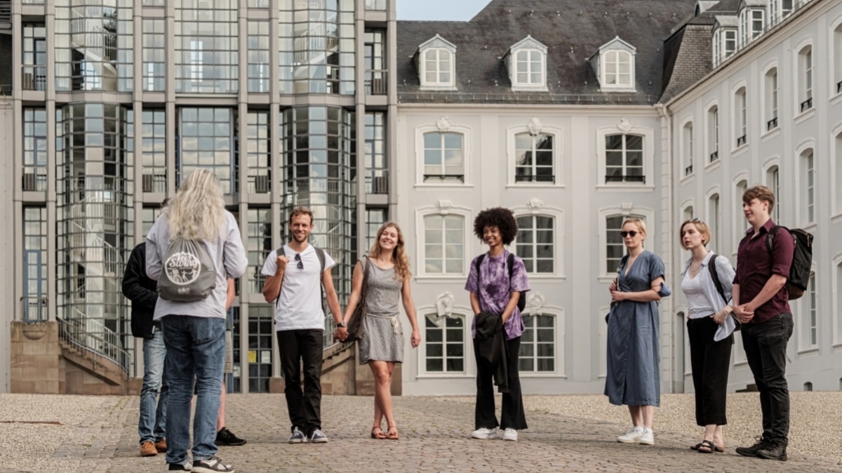 Gruppe von Touristen während einer Stadtführung vor dem Saarbrücker Schloss