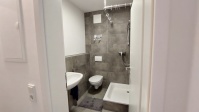 innenliegendes Bad mit Dusche, Waschbecken, WC, dunkel gefliest, Tür , Wand und Decke weiß