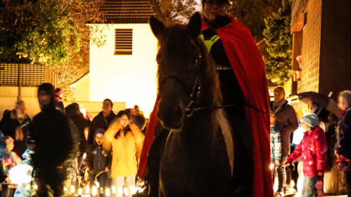 Sankt Martinsumzug in Schafbrücke St. Martin reitet auf einem Pferd und Kinder gehen mit Laternen