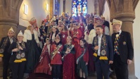 Eine Gruppe Narren steht auf einer Treppe aufgereiht und posiert für ein Foto
