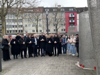 Menschen gedenken an einem Mahnmal