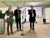 Drei Männer stehen vor einem Mikrofon 