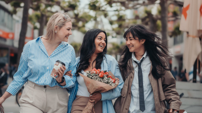 Drei Frauen spazieren durch eine Fußgängerzone